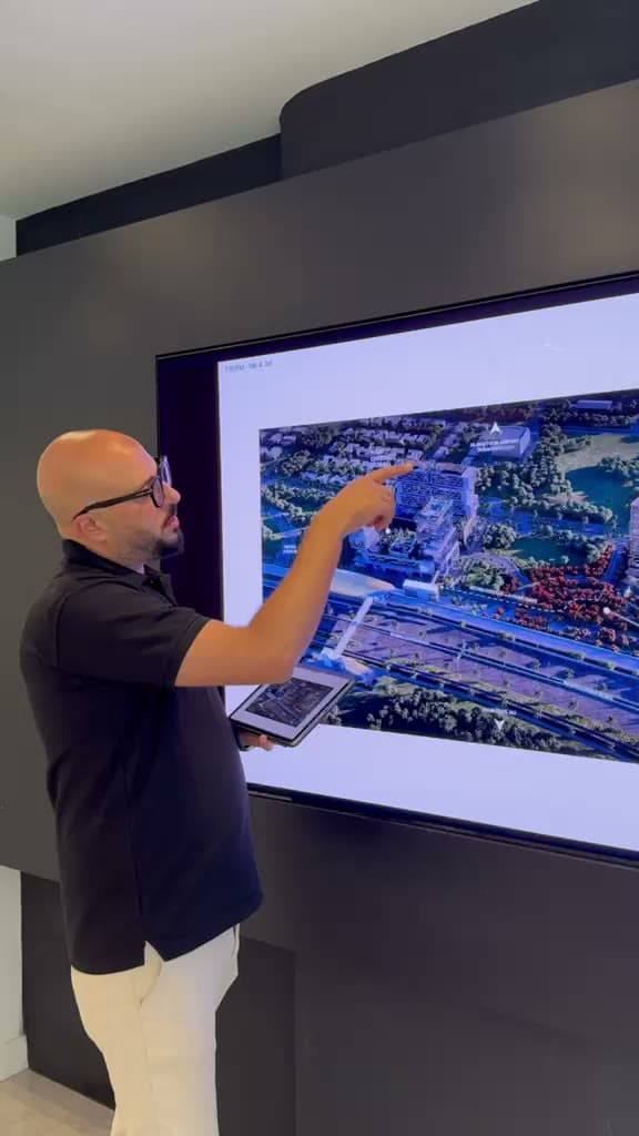 Mahmoud pointing to a development render on a screen
